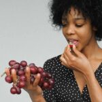 Il resveratrolo contenuto naturalmente nell'uva e quello assunto attraverso un integratore concentrato non sono la stessa cosa. Nel frutto il composto è presente insieme a fibre, acqua e numerose altre sostanze vegetali, mentre le formulazioni in capsule possono fornire quantità molto più elevate. È soprattutto attraverso gli integratori che sono state studiate le dosi maggiori utilizzate nella ricerca clinica. Nel diabete di tipo 2 alcuni studi hanno osservato possibili miglioramenti di parametri come la glicemia a digiuno, l'emoglobina glicata o la sensibilità all'insulina. I risultati, tuttavia, non sono uniformi: le differenze tra dosaggi, durata dei trattamenti, formulazioni e caratteristiche delle persone coinvolte rendono difficile arrivare a una conclusione definitiva. Le evidenze più recenti indicano quindi un potenziale effetto metabolico, ma non sufficiente per considerare il resveratrolo una terapia per il diabete. Un elemento particolarmente importante è la biodisponibilità. Il resveratrolo viene assorbito rapidamente, ma viene anche sottoposto a un intenso metabolismo nell'organismo. Di conseguenza, l'aumento della quantità assunta non comporta necessariamente un aumento proporzionale della sostanza disponibile per i tessuti. Per questo motivo la ricerca sta valutando anche formulazioni e sistemi di somministrazione capaci di migliorarne la disponibilità nell'organismo. C'è poi il tema della sicurezza. Un integratore non deve essere considerato innocuo soltanto perché contiene una sostanza presente negli alimenti. A dosaggi elevati il resveratrolo può provocare disturbi gastrointestinali e, soprattutto in presenza di altre terapie, è necessario considerare la possibilità di interazioni farmacologiche. La prudenza è quindi particolarmente importante per chi assume farmaci per il diabete, anticoagulanti, antiaggreganti o altre terapie continuative. Anche l'eventuale effetto sulla glicemia merita cautela: se una sostanza influenza il metabolismo del glucosio, non è opportuno aggiungerla autonomamente a una terapia già prescritta con l'obiettivo di abbassare ulteriormente i valori. Un integratore non sostituisce i farmaci antidiabetici, né le modifiche dello stile di vita che rappresentano i pilastri della gestione della malattia. In altre parole, mangiare una porzione di uva e assumere resveratrolo in capsule sono due comportamenti nutrizionalmente e farmacologicamente differenti. L'uva può essere inserita, nelle quantità appropriate, anche nell'alimentazione di chi ha il diabete; l'integratore concentrato è invece una scelta che va valutata caso per caso, soprattutto quando sono presenti terapie o altre condizioni di salute